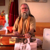 Acharya Mangalananda playing the harmonium